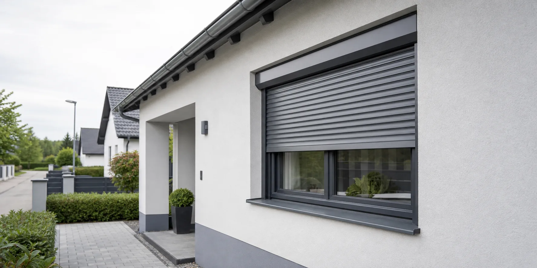 Wohnhausfassade mit grauem Rolladen und Fuehrungsschienen fuer Rolladen Reparatur in Strasshof an der Nordbahn
