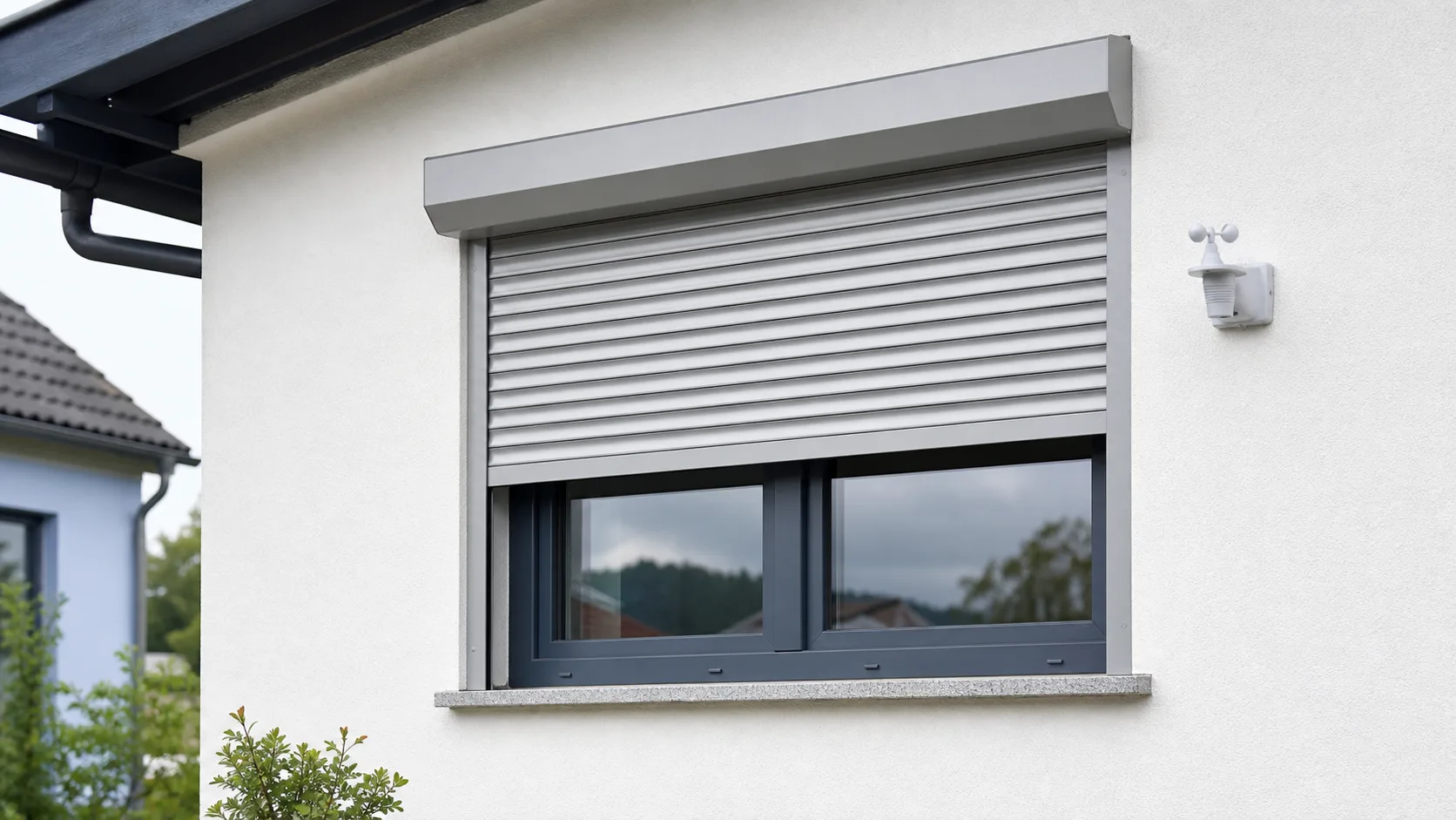 Neutraler motorisierter Rolladen mit Wind- und Sonnensensor an einer Fassade ohne Logo oder Markenaufschrift
